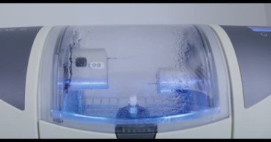 CNC diş makinesi suyla döndürerek ve parlatarak diş implantı yapıyor.