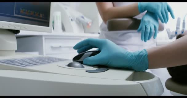 Стоматолог использует медицинский компьютер для уточнения диагноза — стоковое видео