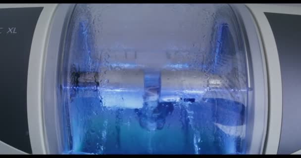 CNC-tannmaskin lager et tannimplantat ved å rotere og polere det med vann – stockvideo