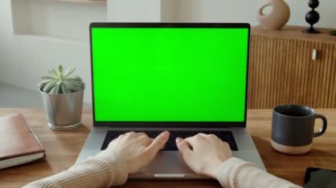 Laptop klavyesinde yeşil ekran ile yazan kadın eller