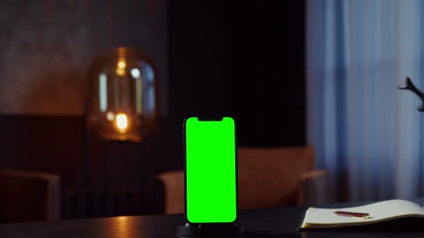 Um telefone celular com uma tela verde fica na área de trabalho da jovem empresária — Vídeo de Stock