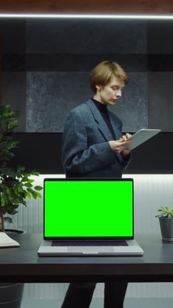 Um computador portátil aberto com a tela verde está em um desktop no escritório da mulher de negócios — Vídeo de Stock