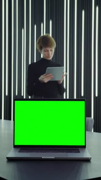 Ein offener Laptop mit grünem Bildschirm steht auf einem Schreibtisch im Büro einer Geschäftsfrau Lizenzfreies Stock-Filmmaterial