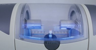 CNC diş makinesi suyla döndürerek ve parlatarak diş implantı yapıyor.