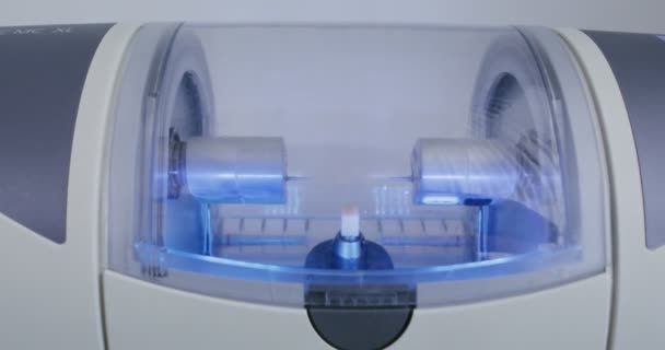 CNC dentalmaskin gör ett tandimplantat genom att rotera och polera med vatten — Stockvideo
