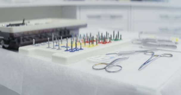 Una mesa de dentistas preparada para trabajar con instrumentos dentales dispuestos en ella — Vídeo de stock