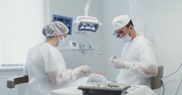 O paciente encontra-se na cadeira dentária durante o tratamento — Vídeo de Stock