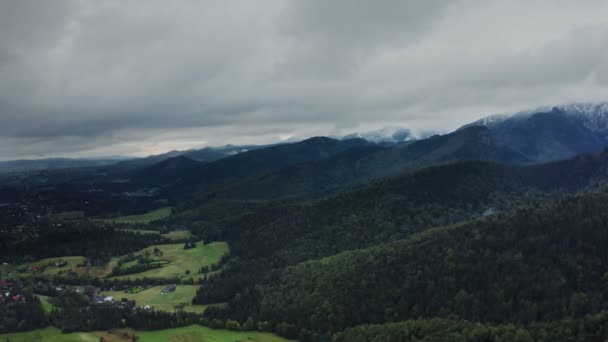 Uitzicht op de bergvallei met stad in het laagland aan de voet van zacht glooiende bergen — Stockvideo