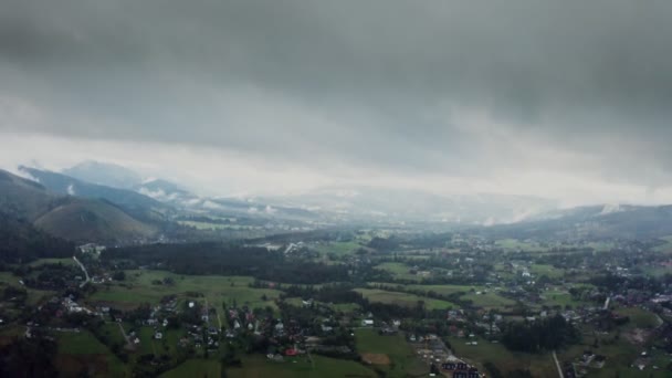 Utsikt över bergsdalen med staden i låglandet vid foten av svagt sluttande berg — Stockvideo