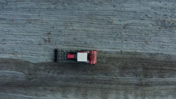 Top view of a red tractor plowing a field — Stock Video