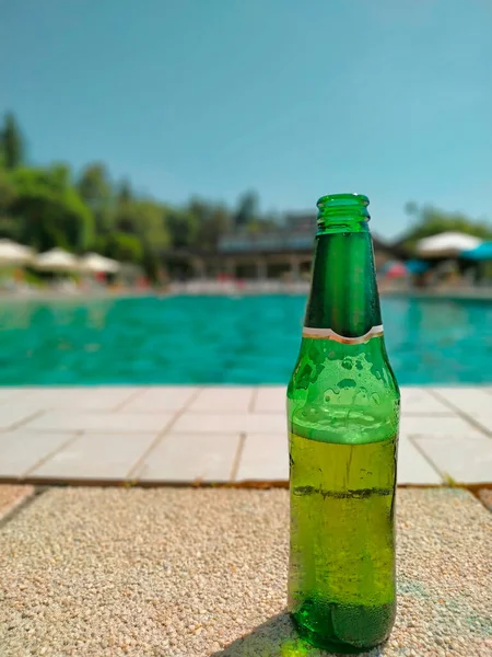 プールエリアの緑のビールボトル — ストック写真