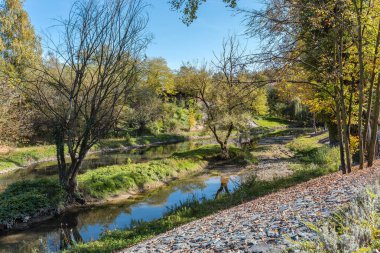 Banja Luka 'daki nehir mavi ve gri berrak gökyüzü ve sudaki ağaç yansıması