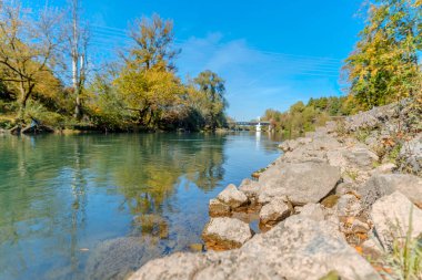 Nehir taşı çamur ve açık mavi gökyüzü ile kaplıdır.