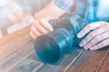 Fotoğrafçı DSRL kamerayı elinde tutuyor. 