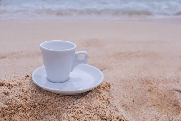 Sabahları kumların üzerinde beyaz kahve fincanı