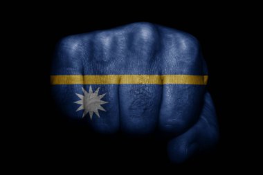 Siyah arka planda güçlü bir yumruğa boyanmış Nauru bayrağı