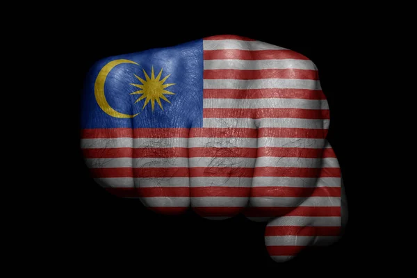 马来西亚国旗在黑色背景上的有力拳头上彩绘 — 图库照片