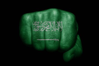 Suudi Arabistan bayrağı siyah arka planda güçlü bir yumruğa boyanmış.