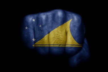 Tokelau bayrağı siyah arka planda güçlü bir yumruğa boyanmış.