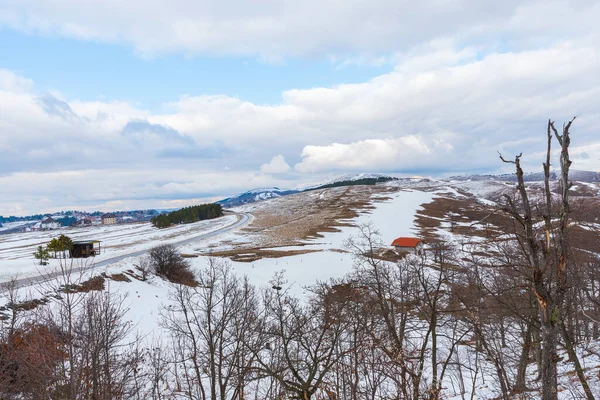 Krajobraz Górskiej Asfaltowej Zimowej Drogi Wiejskiej Zachmurzonym Niebem Małymi Domkami — Zdjęcie stockowe