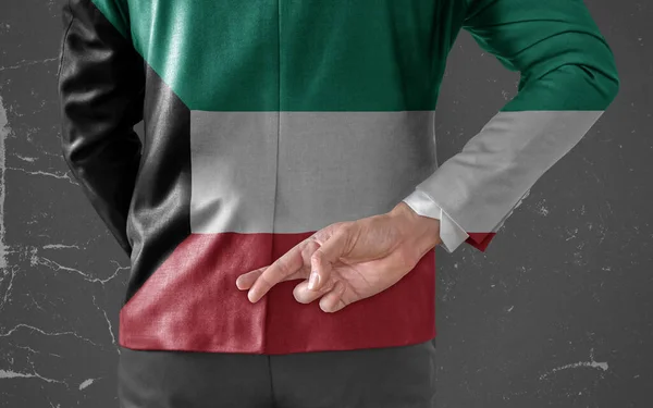 彼の指でクウェートの旗とビジネスマンジャケット彼の背中の後ろに交差 — ストック写真