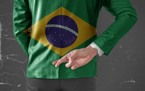 彼の指でビジネスマン上のブラジルのジャケットフラグは 彼の後ろに交差 — ストック写真