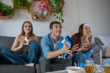 Üç genç Arjantinli arkadaş, iki kız ve bir oğlan futbol seyrediyor, hayal kırıklığına uğramış ve çaresiz..