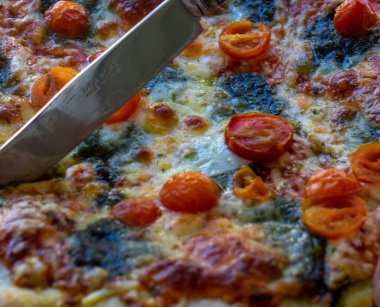 Bıçak sebze malzemelerinden pizza kesiyor.