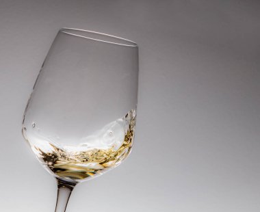Beyaz şarap kadehi mavi-beyaz arka planda hareket ediyor