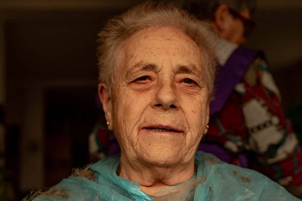 Sentada Anciana Que Está Cortando Pelo Casa Por Otra Persona — Foto de Stock