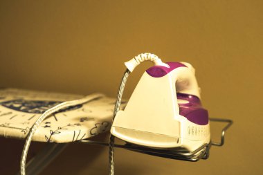 Ütülendiği masayı destekleyen demire yerleştirilmiş ev ütüsü.