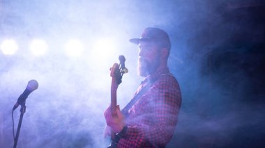 Bir gecede sakallı ve şapkalı bir adamın silueti aynaya yansıyor.