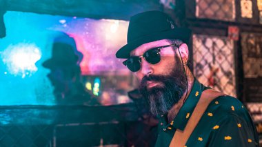 Bir gecede sakallı ve şapkalı bir adamın silueti aynaya yansıyor.