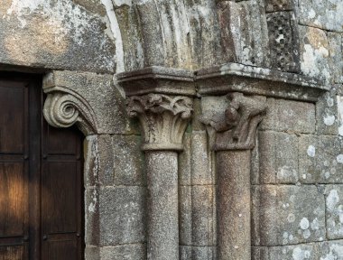 Sütunlarda taş başkentler ve Romanca bir kapı.