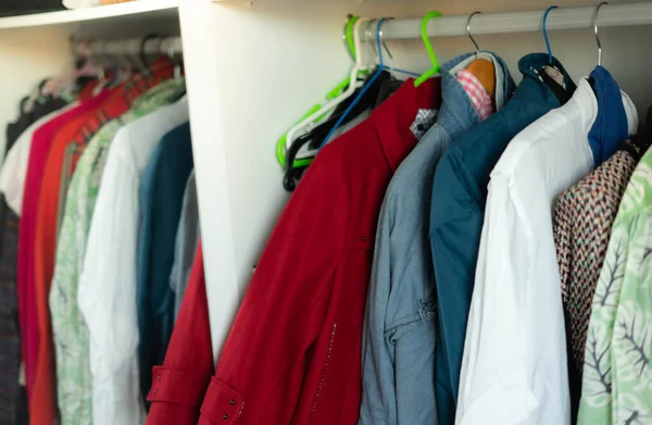 clothes hanging on hangers inside a closet