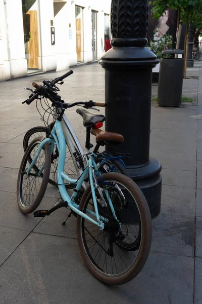 two bicycles supported by a street lamp for sustainable mobility in the city