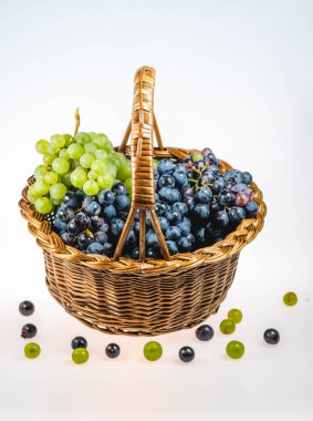 Bir sepet bitkisel malzeme yere düşmüş üzümlerle dolu.