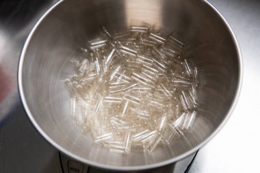 Kapsül dolum makinesi. Beslenme takviyeleri için şeffaf kapsüller.