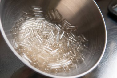 Kapsül dolum makinesi. Beslenme takviyeleri için şeffaf kapsüller.