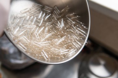 Kapsül dolum makinesi. Beslenme takviyeleri için şeffaf kapsüller. Kursların kapsül mikro dozlarının oluşturulması