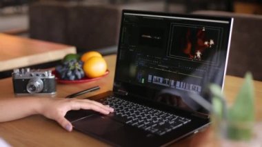 Freelancer video editörü kadın dizüstü bilgisayarda film düzenleme yazılımıyla çalışıyor. Vlog düzenleyen kadın videograf ya da blogger kameraman. Kaydırıcı izleme çekimi.