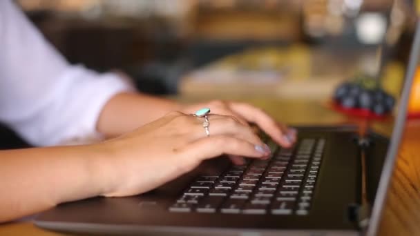 Kamera meluncur di sekitar freelancer perempuan tangan mengetik di keyboard laptop di kafe. Pebisnis wanita yang bekerja di kantor dengan internet. Wanita mencari pekerjaan baru di internet di coffeeshop. Konsep bisnis. — Stok Video