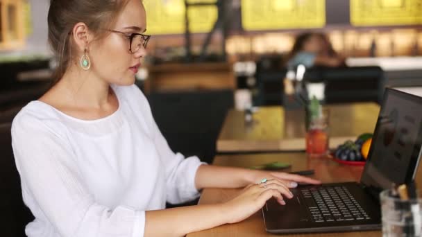 Smíšené rasy freelancer transformuje kabriolet notebook na tablet při práci v kavárně. Asijská běloška s transformátorovým zápisníkem. Digitální umělec používá 2 v 1 počítači s dotykovou obrazovkou. — Stock video