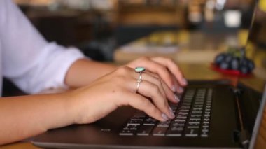 Kafedeki dizüstü bilgisayarlı klavyede daktilo kullanan kadın serbest çalışanların elinde kameralar kayıyor. Ofiste internetle çalışan bir iş kadını. Kadın internet üzerinden kahve dükkanında yeni bir iş arıyor. İş konsepti.