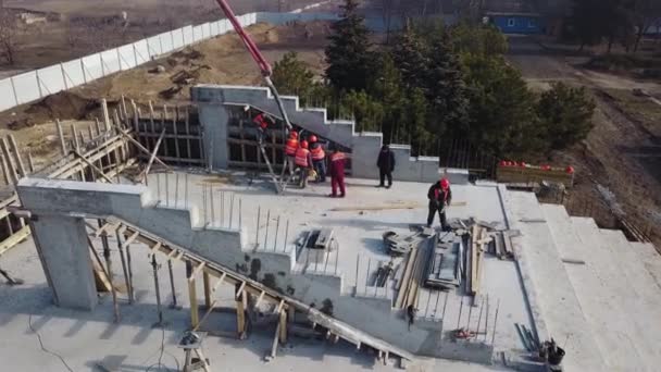 Ukraine, Mariupol - 2020 년 9 월 1 일. 콘크리트 펌프 크레인 팔 트럭 과 건물의 혼합물을 포스트 워크로 쏟아 부었습니다. 건축 봉사자들 이 호민관 무대의 콘크리트 벽을 쌓고 있다. — 비디오