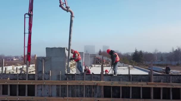 Ukraine, Mariupol - 1er septembre 2020. Aerial of concrete boom pump grue arm truck with outriggers couling building mixture into a formwork. Les travailleurs de la construction versent des murs en béton de tribune. — Video