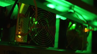 Bitcoin madencileri büyük çiftlikte. Kürsüdeki ASIC madencilik ekipmanları çelik konteynırdaki kripto para birimini rafa kaldırıyor. Engelleme teknolojisi. Güç kaynağı vantilatörleri ve ızgaralar. Sunucu odası ışıkları.