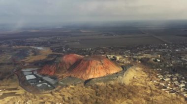 Bulutlu bir günde kömür madeni asansörü ve kömür yığınları. Eski kömür madenleri, yıpranmış fabrikalar ve inşaatlar. Fosil yakıt ve mineraller bölgelerle ağır sanayi arazileri kazıyor..