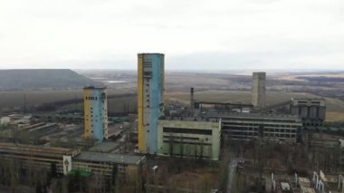 Bulutlu bir günde kömür madeni asansörü ve kömür yığınları. Eski kömür madenleri, yıpranmış fabrikalar ve inşaatlar. Fosil yakıt ve mineraller bölgelerle ağır sanayi arazileri kazıyor..