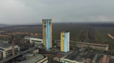 Bulutlu bir günde kömür madeni asansörü ve kömür yığınları. Eski kömür madenleri, yıpranmış fabrikalar ve inşaatlar. Fosil yakıt ve mineraller bölgelerle ağır sanayi arazileri kazıyor..